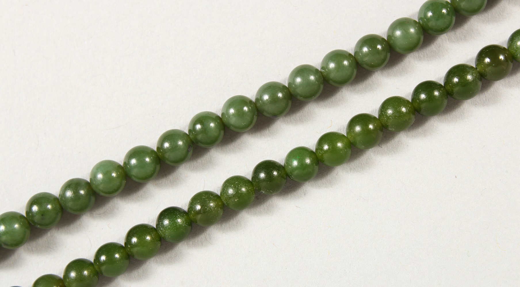 A JADE BEAD NECKLACE, with 9ct gold clasp; together with a similar bracelet. Necklace: 17ins long.