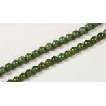 A JADE BEAD NECKLACE, with 9ct gold clasp; together with a similar bracelet. Necklace: 17ins long.