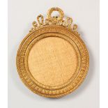 AN EMPIRE STYLE GILT METAL CIRCULAR PHOTOGRAPH FRAME, with ornate cresting. 7ins high x 5.5ins