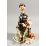 A CAPODIMONTE GROUP, a man with a hurdy gurdy, a dog by his side. 6ins wide.