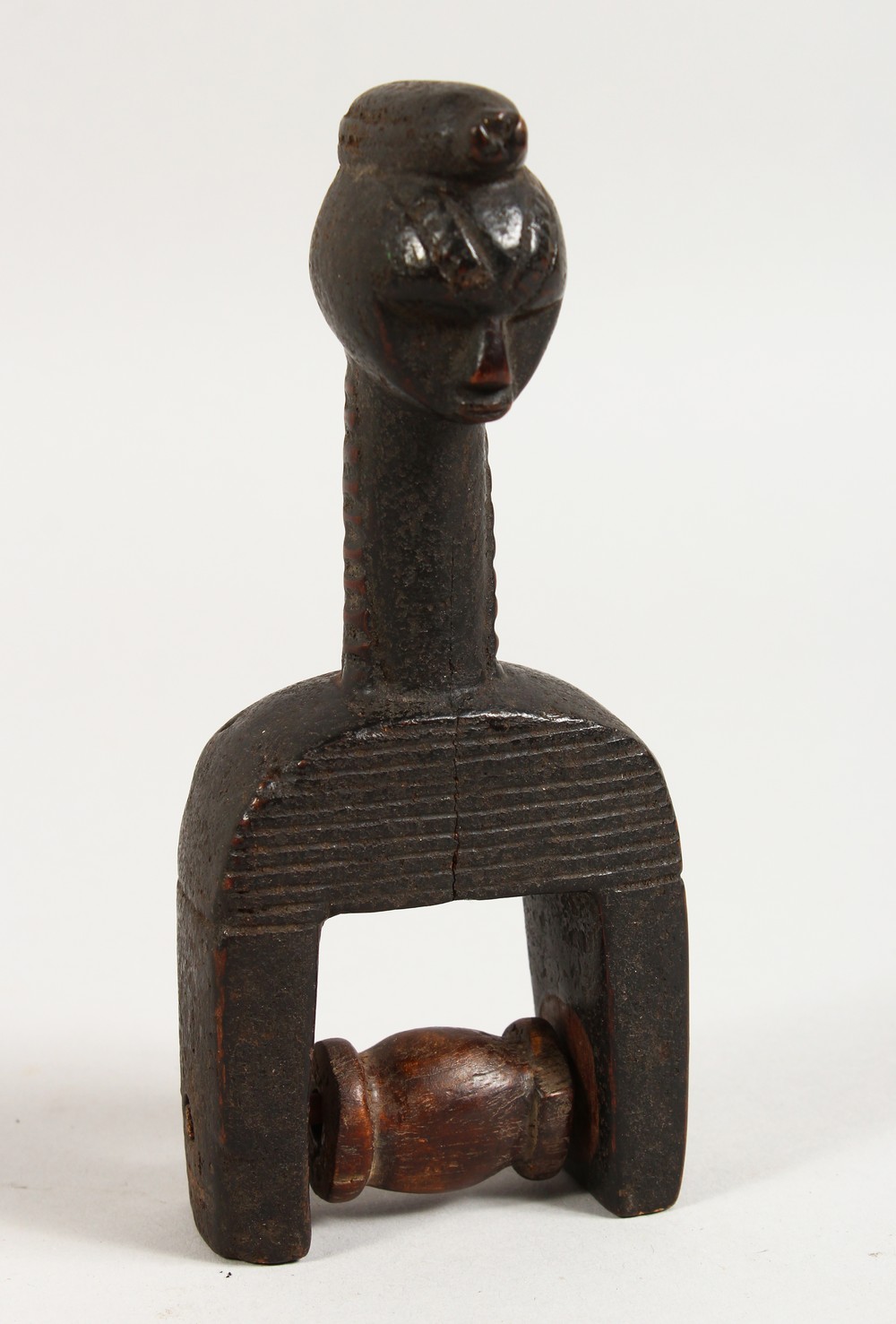 AN AFRICAN CARVED WOOD FIGURAL PULLEY. 6.5ins high.