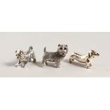 THREE CAST SILVER MINIATURE DOGS.