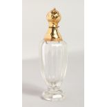 A CUT GLASS PERFUME BOTTLE, with a gold top. 4ins high.
