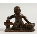 A SMALL JAPANESE BRONZE OF A SEATED BOY. 3ins long.