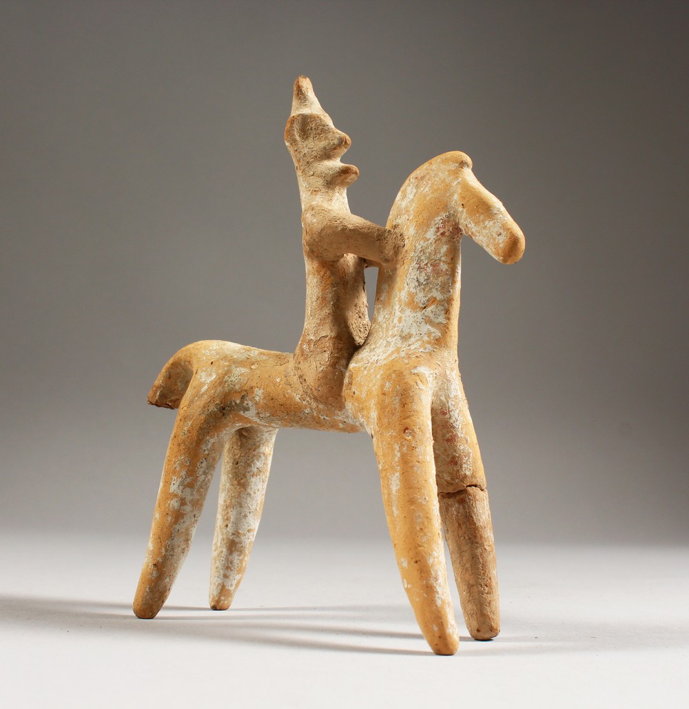 AN EARLY GREEK/CYPRIOT TERRACOTTA MODEL OF A HORSE AND RIDER. 6ins high.