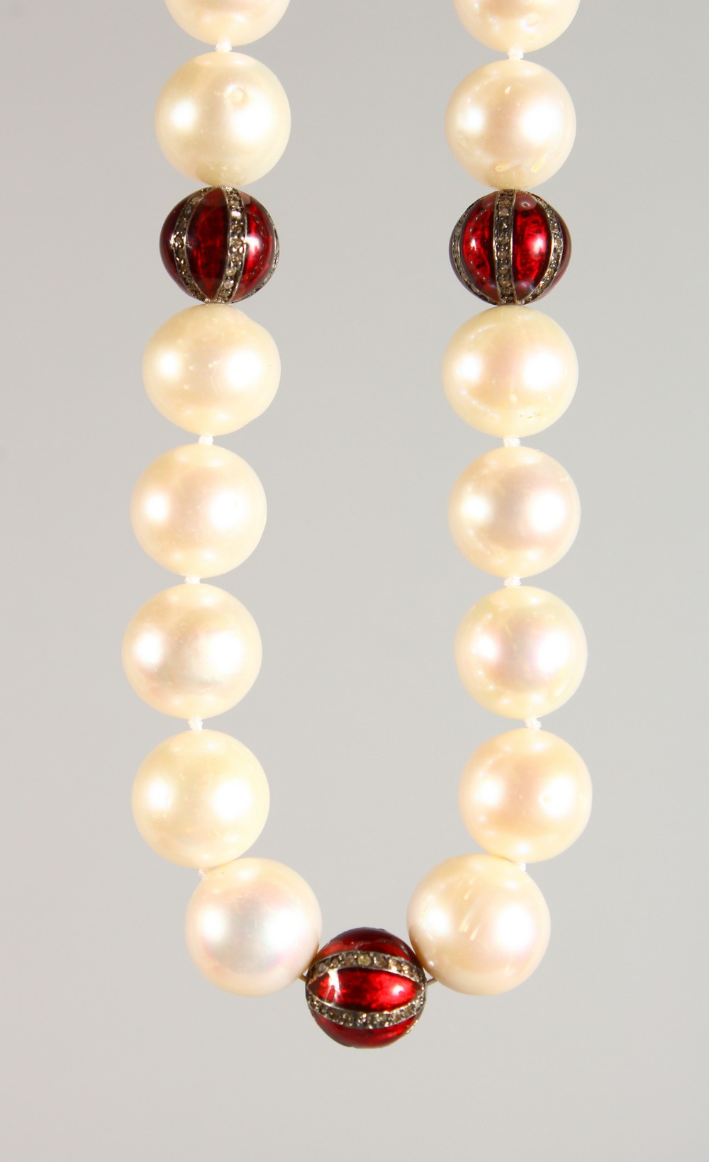 A PEARL NECKLACE, with three diamond and enamel sections and 18ct gold clasp. 18ins long.