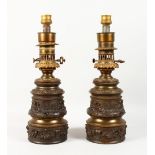 A GOOD PAIR OF 19TH CENTURY FRENCH BRONZED LAMPS with classical cupid decoration. 15ins high.