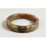 A MOTTLED JADE BANGLE. 3ins diameter.