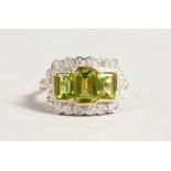 A 9CT GOLD THREE STONE PERIDOT AND DIAMOND RING.