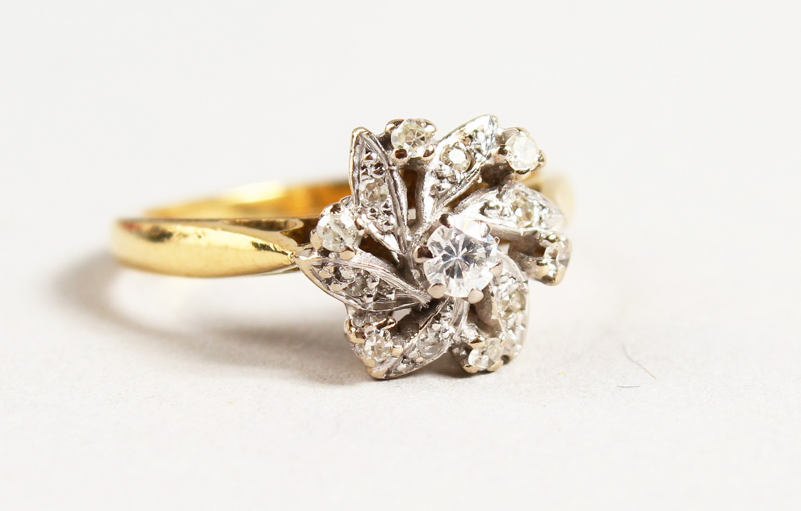 AN 18CT GOLD DIAMOND CLUSTER RING.