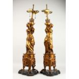 A VERY GOOD PAIR OF 19TH CENTURY OF GILDED BRONZE LAMPS, formed as young classical ladies holding an