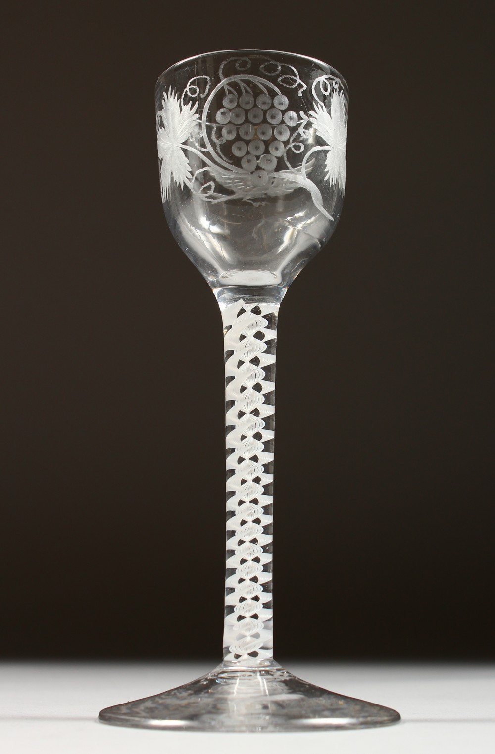 A GEORGIAN WINE GLASS, the bowl engraved with fruiting vines, with white air twist stem. 6ins high.