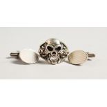 A SILVER SKULL RING and silver cuff links.