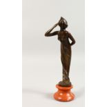 A SMALL ART NOUVEAU BRONZE OF A YOUNG LADY blowing a kiss, on a circular onyx base. 8.5ins high.