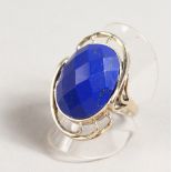 A SILVER RING with blue facet cut oval stone.