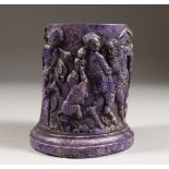 A PURPLE RESIN OVAL URN, the relief with Roman figures. 5.5ins high.