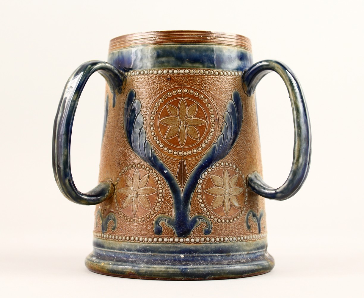 A DOULTON STONEWARE THREE HANDLED TYG with blue decoration. 7ins high.