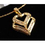 A 9CT GOLD DOUBLE HEART SHAPED DIAMOND SET PENDANT on a chain.