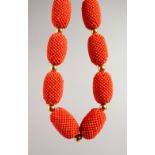 A GOOD CORAL AND SILVER GILT NECKLACE set with ten various coral beads made up of hundreds of