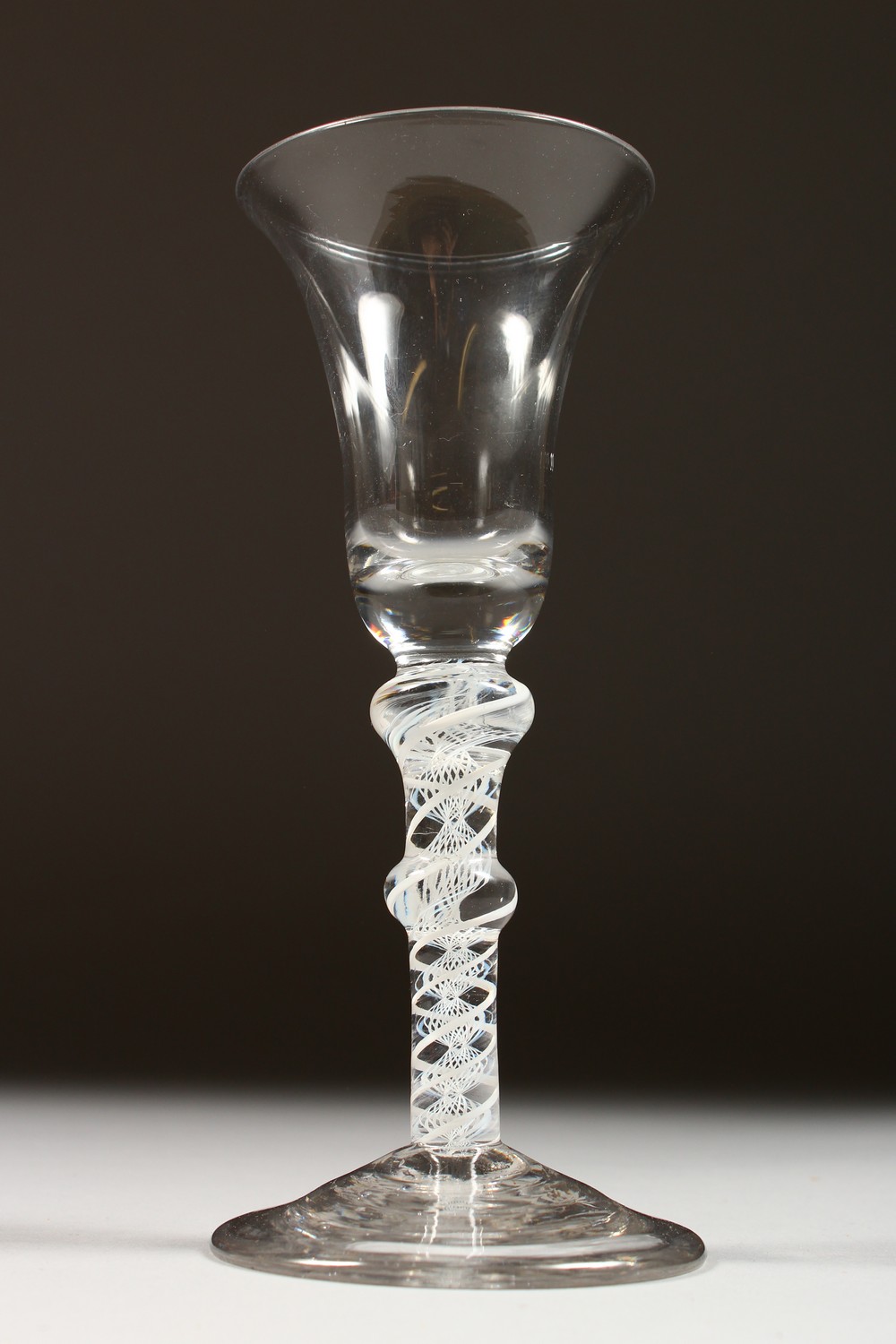 A GEORGIAN WINE GLASS with inverted bell shaped bowl and two knops to the stem and white air