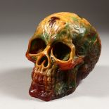 A CARVED RESIN SKULL. 6ins long.