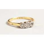 AN 18CT GOLD THREE STONE DIAMOND RING.