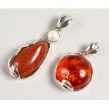 TWO SILVER AND AMBER PENDANTS.