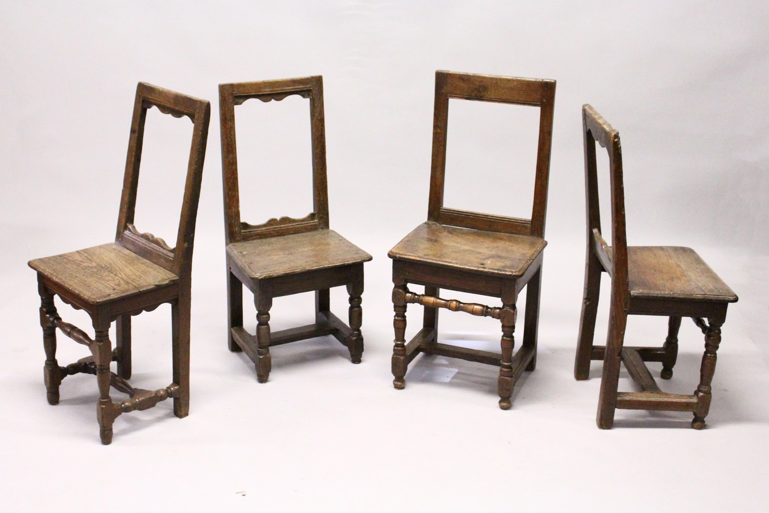 FOUR SMALL 18TH CENTURY OAK DINING CHAIRS, with framed backs, solid seats, on turned and stretchered