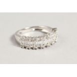 AN 18CT GOLD THREE ROW DIAMOND HALF HOOP RING.