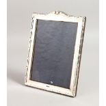 A SERPENTINE TOPPED PHOTOGRAPH FRAME. 10ins x 7.5ins.