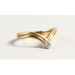 AN 18CT GOLD DIAMOND AND WISHBONE RING.