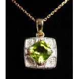 A 9CT GOLD PERIDOT AND DIAMOND PENDANT on a chain.