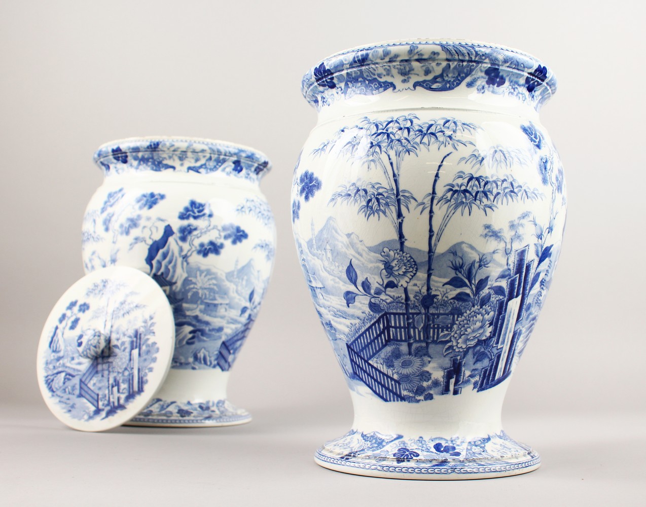 A GOOD PAIR OF WEDGWOOD BLUE AND WHITE VASES WITH LIDS with a Chinese landscape pattern. Impressed