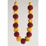 A GOOD NATIVE SILVER AND SILVER GILT NECKLACE set with ten maroon beads interspaced with gilt