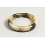 A MOTTLED JADE BANGLE. 3ins diameter.