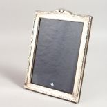 A SERPENTINE TOPPED PHOTOGRAPH FRAME. 10ins x 7.5ins.