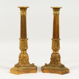 A GOOD PAIR OF LOUIS XVITH ORMOLU CANDLESTICKS on triangular bases. 13ins high.