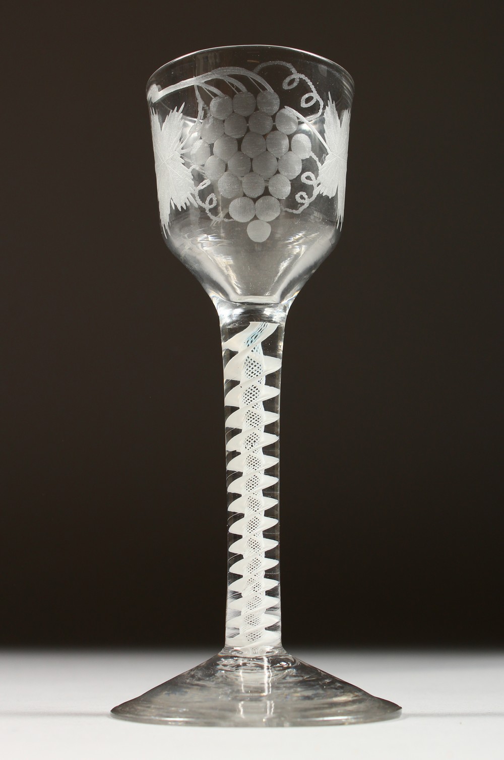 A GEORGIAN WINE GLASS, the bowl engraved with fruiting vines, with white air twist stem. 5.75ins