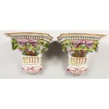 A PAIR OF SEVRES STYLE PORCELAIN WALL BRACKETS painted with figures and hung with garlands. 10ins