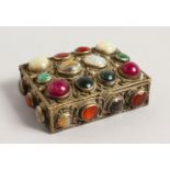 A SMALL GILDED BOX set with semi-precious stones. 3ins long.