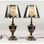 A PAIR OF BLACK AND WHITE TOLEWARE URN SHAPED VASES AND SHADES, converted to electricity.