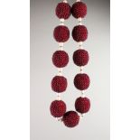 A GOOD NATIVE MAROON COLOURED BEAD AND PEARL NECKLACE set with eleven maroon beads made up of