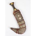A GOOD 19TH CENTURY OR EARLIER ISLAMIC JAMBIYA DAGGER, with a leather sheath decorated with silver