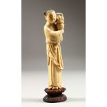 A GOOD 19TH CENTURY CHINESE CARVED IVORY FIGURE OF A FRUIT SELLER, the lady stood holding a basket