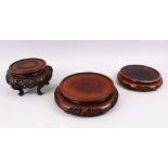 THREE CHINESE HARDWOOD CIRCULAR STANDS, One with curving legs, for vases 7.5" , 7" & 5" diameter. (