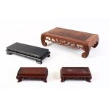 FOUR 20TH CENTURY CHINESE HARDWOOD RECTANGULAR STANDS, the largest in the form of a low opium table,