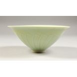 A CHINESE PALE CELADON CONICAL SHAPED PORCELAIN BOWL, with stylized leaf moulded decoration, 15.