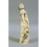 AN EARLY 20TH CENTURY CHINESE CARVED IVORY FIGURE, of a young lady standing with a bird by her side,