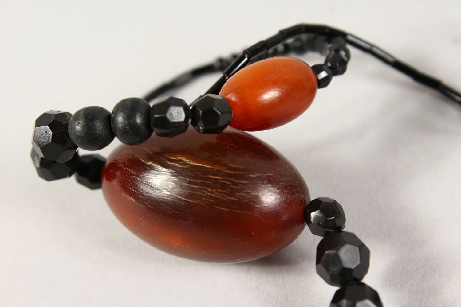 A GOOD CHINESE RHINO HORN BEAD NECKLACE, with nine oval beads of various size, interspaced with a - Image 2 of 6