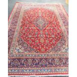 LARGE RED GROUND RUG LABELLED 'MADE IN IRAN 334 X 232'